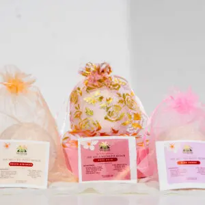 Three decorative gift bags in pink and gold hues on a white surface.
