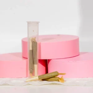 Pink adhesive tape rolls and beige masking tape on a white surface.